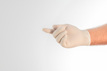 The hand of a doctor covered by a glove on a white background. Writing space.