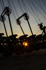 Fragment of a multi-bucket excavator giant against the light against the sunset