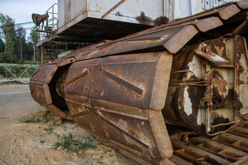 Fototapeta na wymiar Old rusty tracks of a giant excavator