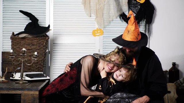 Father, mother and son in halloween costumes have fun, hugging and smiling. Boy hugs his mom and father, halloween party at home. Trick or treat. Family Halloween Celebration Traditions. Happy family.