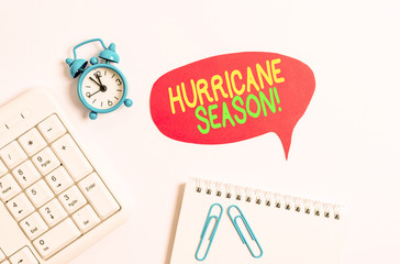 Word writing text Hurricane Season. Business photo showcasing time when most tropical cyclones are expected to develop Blank paper with copy space on the table with clock and pc keyboard