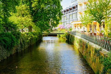 Fototapeta na wymiar Cafe and restaurant in Gonneranlage Kurpark in Old city of Baden Baden in Baden Wurttemberg in Germany. Cityscape view of green rose garden in Bath and spa German town in Europe. Landscape in summer.