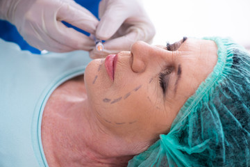 Old woman visiting male doctor for plastic surgery