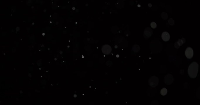Flying dust particles on a black background