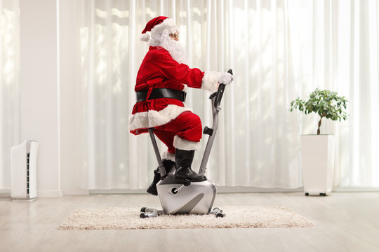 Santa Claus Exercising On A Stationary Bicycle