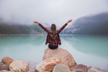 Woman looking out at Lake Louise in Banff National Park, Alberta, Canada on a foggy day