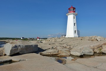 Fototapeta na wymiar View of the Peggy’s Point lighthouse, located in Peggy’s Cove outside of Halifax, capital of the Canadian province of Nova Scotia, in St Margaret’s Bay