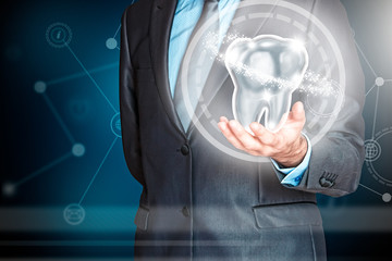 Businessman holding a dental piece in his hand. Insurance, health and economy care