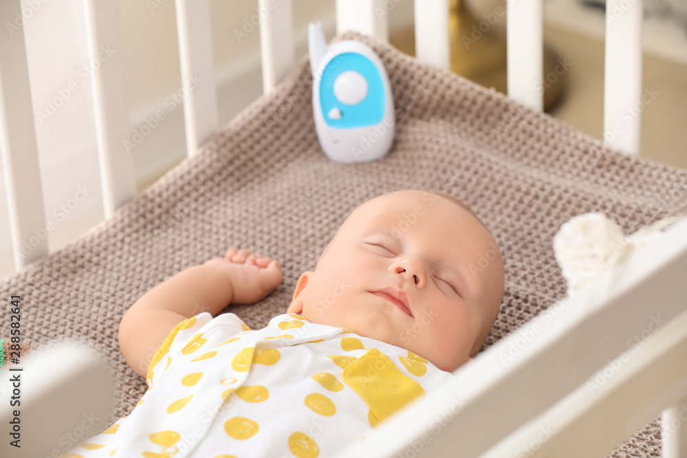 Wall mural modern baby monitor in crib of cute sleeping infant