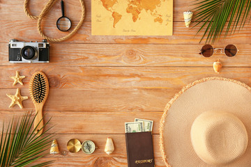 Frame made of female accessories and travel items on wooden background