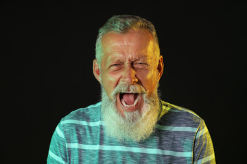 Angry mature man on dark background