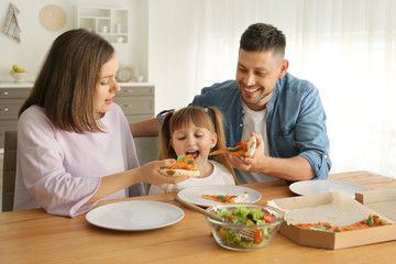 Happy family eating pizza at home