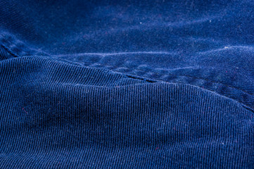 clothing items stonewashed cotton fabric texture with seams, clasps, buttons and rivets, macro