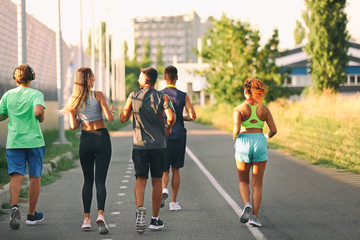Group of sporty young people running outdoors