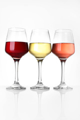 Glasses of different wine on white background