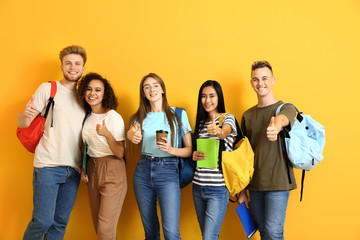 Group of students showing thumb-up gesture on color background