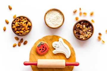 Cooking creepy cookies concept with almonds, pin, flour on white background top view