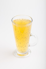 Glass of tangerine orange colored drink with basil seeds isolated on white background. Side view.