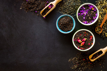 Dry leaves of herbal tea frame on black background top view mock-up