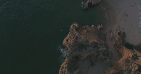 Aerial sunset view of Praia dos Tres Irmaos (Three Brothers beach) in Alvor, famous tourist destination in Western Algarve Coast, Portugal.