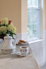 Morning Tea on a Marble Table in a Gold and White Dining Room in Front of a Window