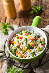 Cooked white rice mixed with colorful vegetables (onion, carrot, green peas, corn, green beans) in bowl (Selective Focus, Focus one third into the dish)