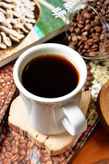 Cup of Ethiopian coffee with coffee beans on a wooden table