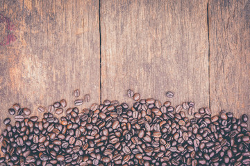 Coffee beans on old grunge wood table for background