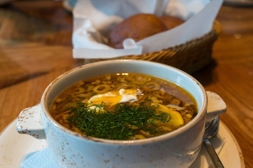Borscht or borsht soup in a rustic bowl with sour cream and dill