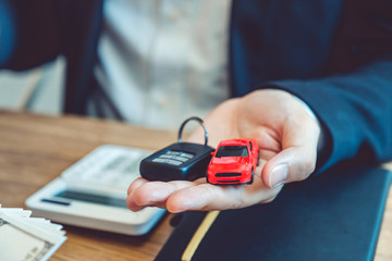 Sale agent giving Car key to customer and sign agreement contract, Insurance car concept.