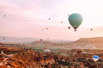 Kleurrijke heteluchtballonnen die over de vallei vliegen bij de populaire reisbestemming van Cappadocië in de tijd van de zonsopgang in Turkije