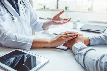 Doctor holding hands for comforting and care patient hospital and medicine concept