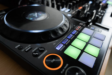 Fototapeta premium Professional concert dj turntables player device with sound mixer panel and jog wheel.Club disc jockey stage equipment for playing music on party.Digital turn table deck for nightclub