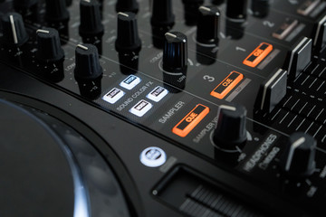 Wide angle photo of black sound mixer controller with knobs and sliders