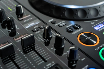 Wide angle photo of black sound mixer controller with knobs and sliders © Gayan