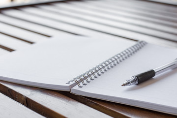 Selective focus of Pen, notebook on the wooden table and copy space