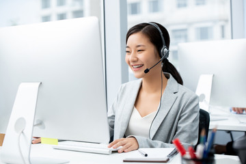 Woman wearing microphone headset working in call center office