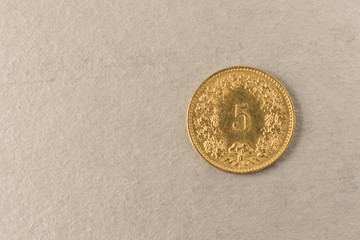 Gold coin on grey background. Close up.