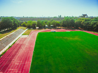 stadium with green grass and red running line