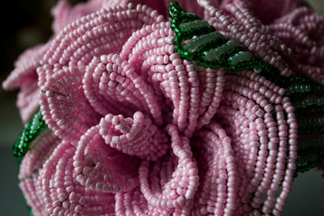 Obraz premium Pink roses from beads on a gray background. Bouquet of roses from beads. Macro shot.