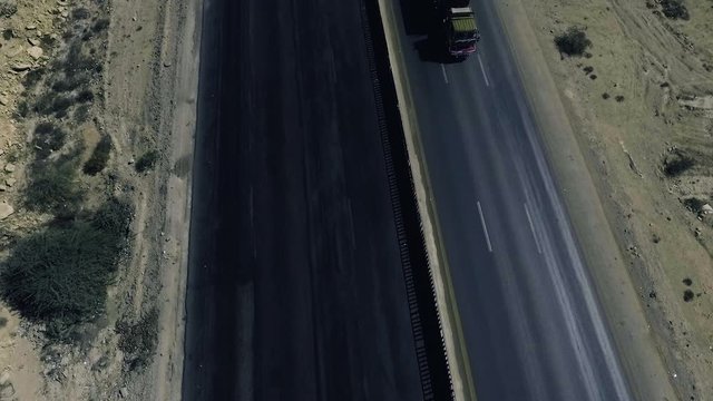 A slow mo aerial top view of a heavy truck moving on a highway in northern areas.