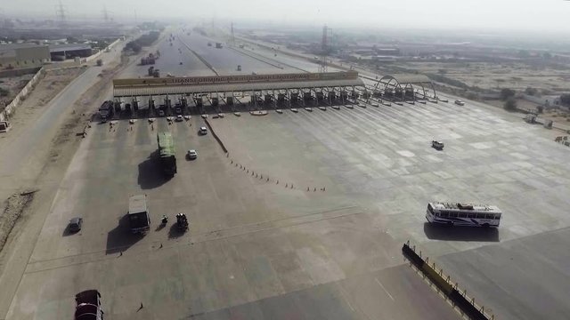 Aerial view of a motorway toll plaza of the city, Heavy vehicles and others entering and crossing.