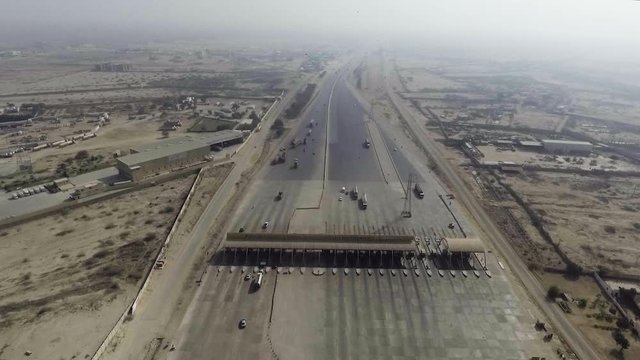 Aerial view of a motorway toll plaza of the city, Heavy vehicles and others entering and crossing.