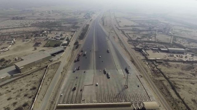 Aerial view of a motorway toll plaza of the city, Heavy vehicles and others entering and crossing.
