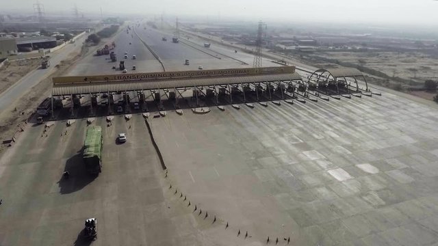 Aerial view of a motorway toll plaza of the city, Heavy vehicles and others entering and crossing.