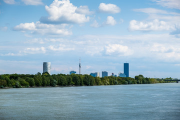 Fototapeta na wymiar VIENNA, AUSTRIA - AUGUST 14, 2019: Summer landscape with river Danube and skyscrapers of Donaustadt at sunset in Vienna