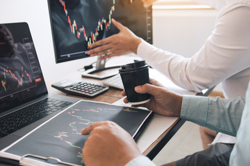 Team of agent trading business people pointing graph and analysis stock market on computer screen in office.