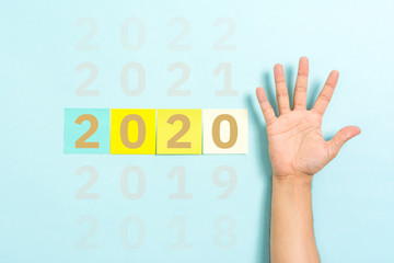 Stop year 2020 concept with hand palm raised on blue background
