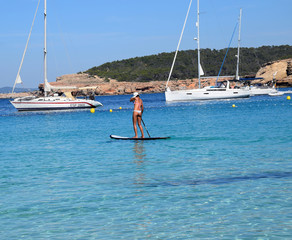 Hermosa mujer haciendo stand up paddle boarding