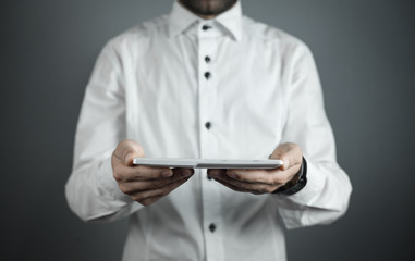 Businessman holding white digital tablet.